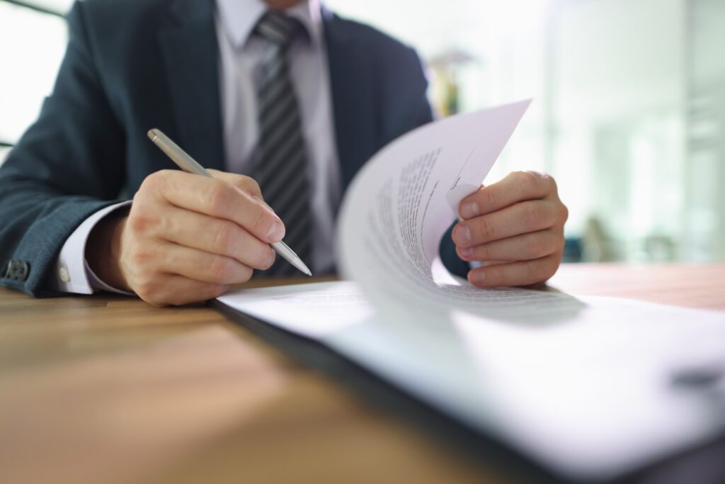 Insurance professional reviewing and signing paperwork, illustrating common insurance company delay tactics faced by claimants in Northridge, California.