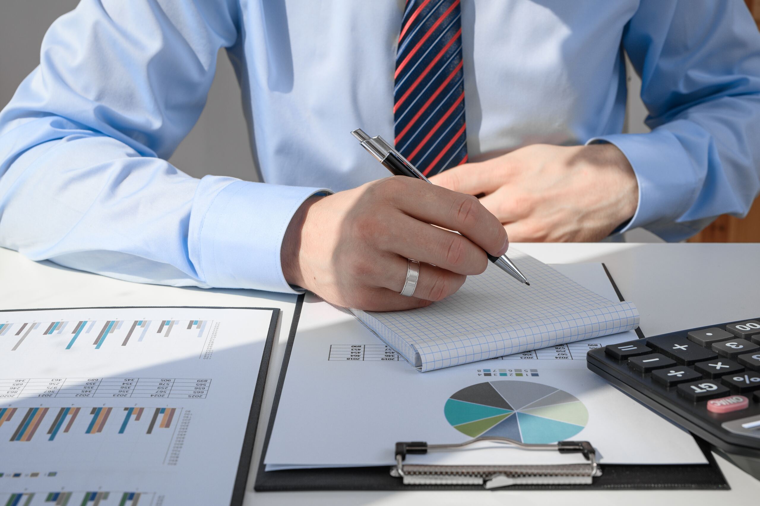 Insurance adjuster analyzing financial documents and reports, showing common insurance company delay tactics used in Northridge, CA claims.
