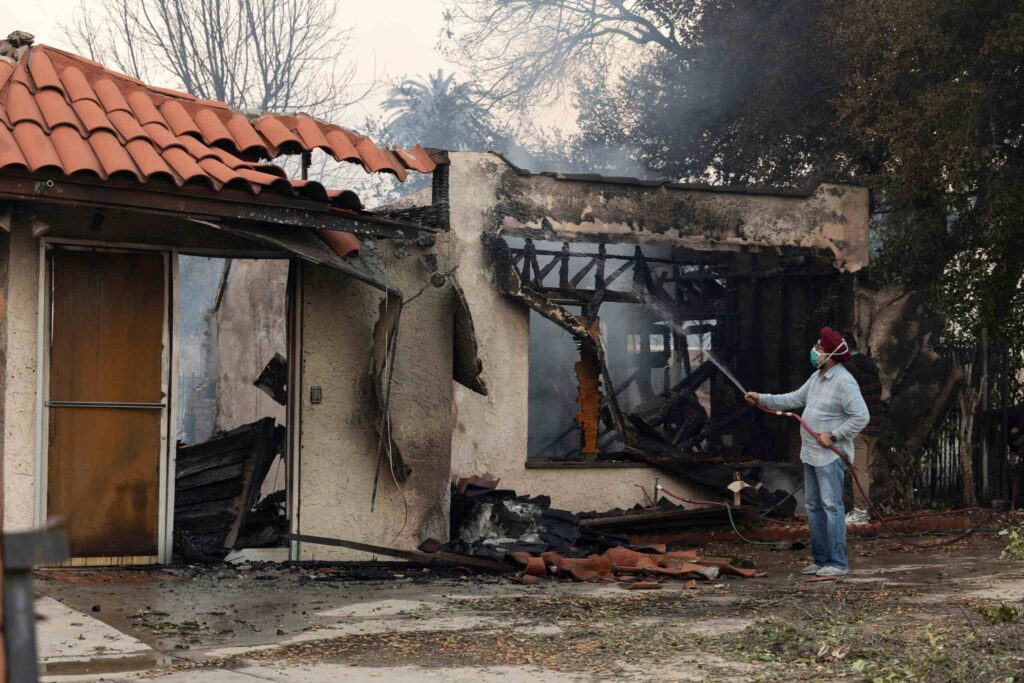 Burned home and ongoing cleanup highlighting insurance company bad faith after a wildfire in Northridge, California.