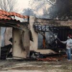 Burned home and ongoing cleanup highlighting insurance company bad faith after a wildfire in Northridge, California.