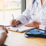 Doctor discussing patient history to prepare insurance paperwork