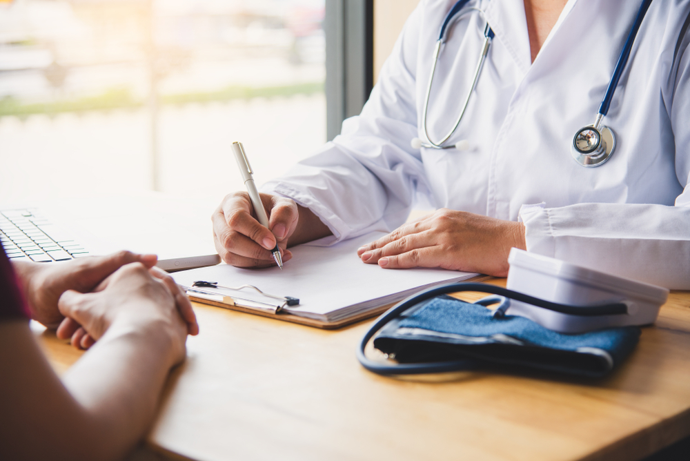 Doctor discussing patient history to prepare insurance paperwork
