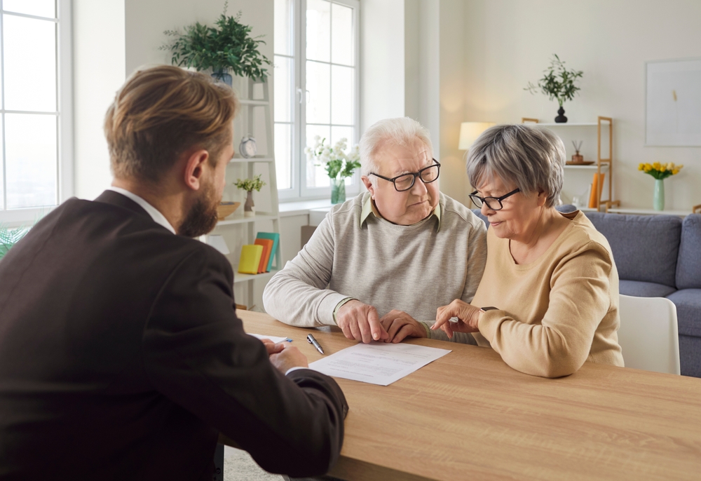 Lawyer reviews an insurance and long-term care contract with a senior couple