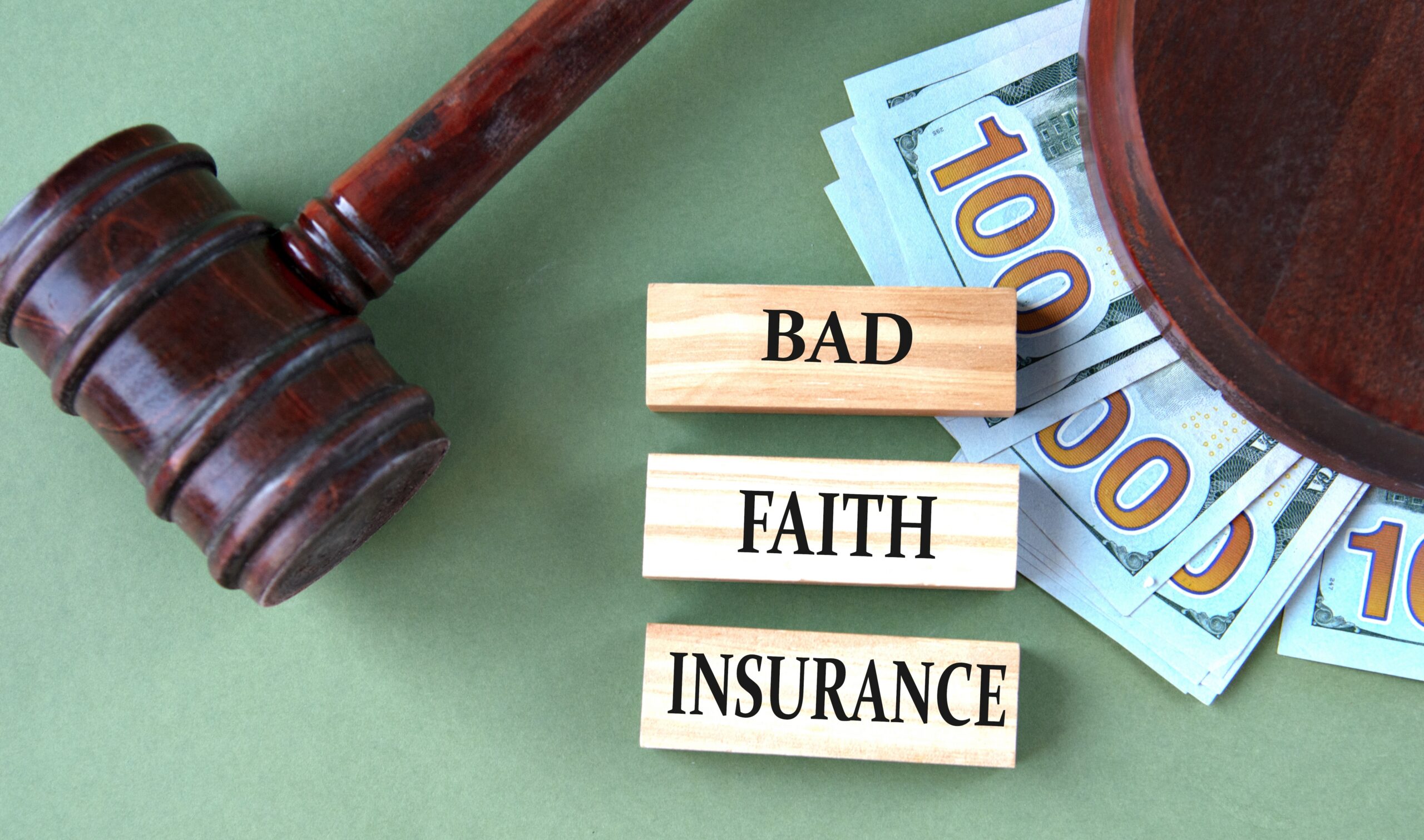 Judge’s gavel and dollar bills next to blocks labeled “Bad Faith Insurance,” representing a Spokane bad faith insurance attorney concept